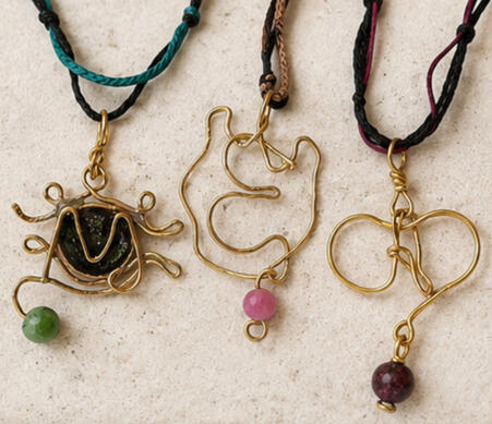 Initial Talismans Three handmade brass Initial Talismans necklaces with the letters A, M and E, semiprecious stones and adjustable macramé cords.