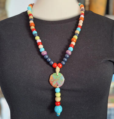 Grape and Blackberry necklace Handmade Grape and Blackberry necklace from the Road Talismans collection, crafted with colorful beads, cord and a round pendant.