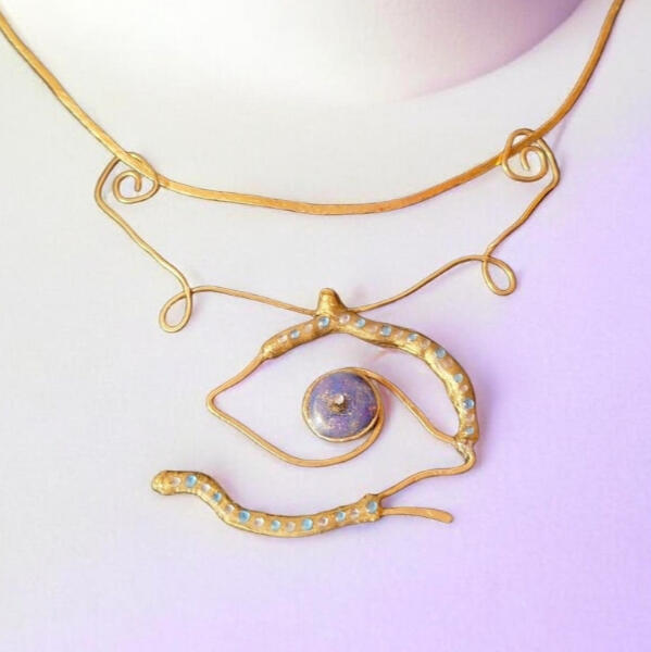 Handmade brass Road Talisman necklace with resin eye center and rhinestone details.